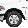Front side of a white RAM 1500 pickup truck with a visible wheel and badge.